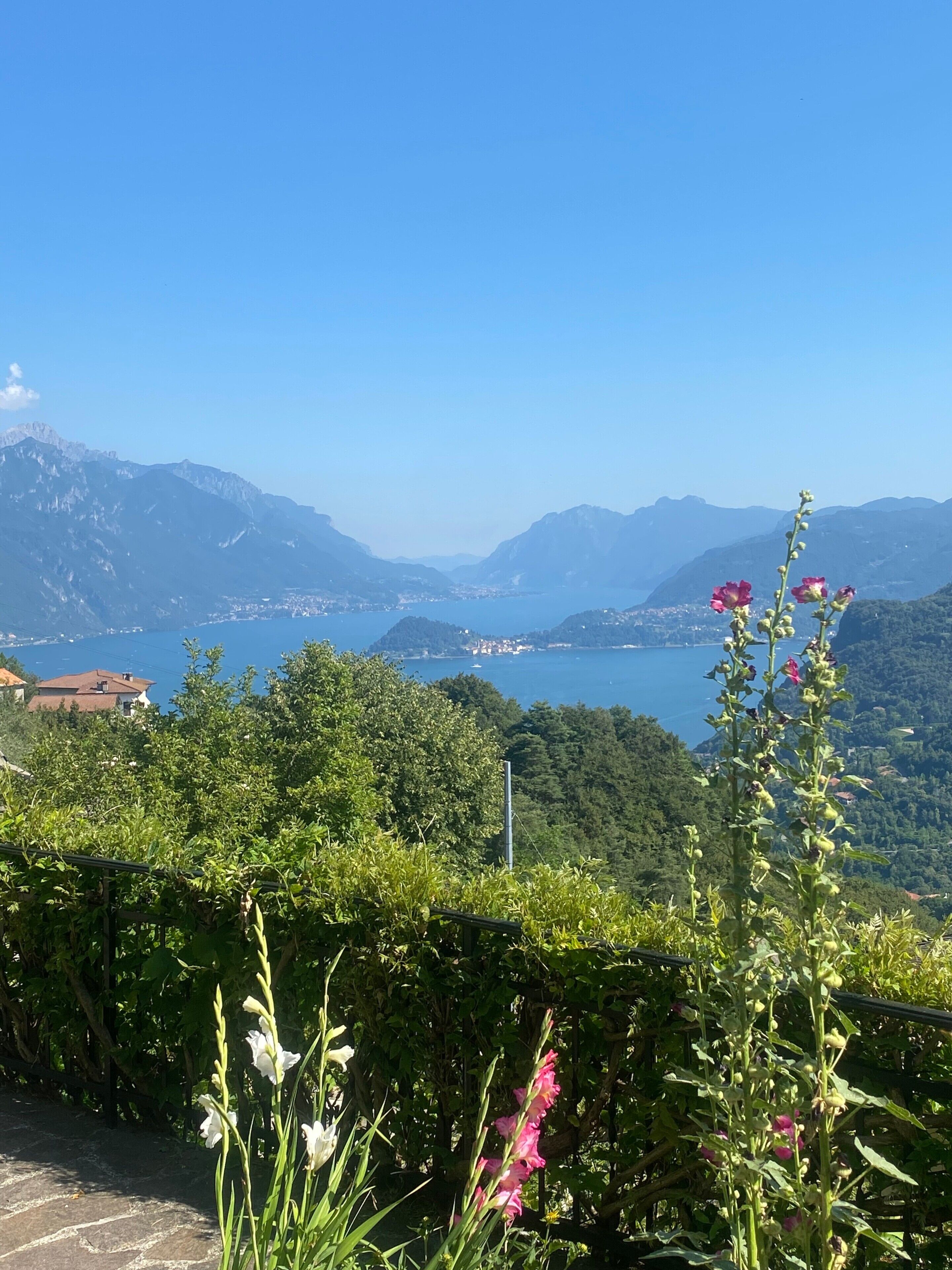 A mountainous landscape with a clear view of a lake and distant buildings.
