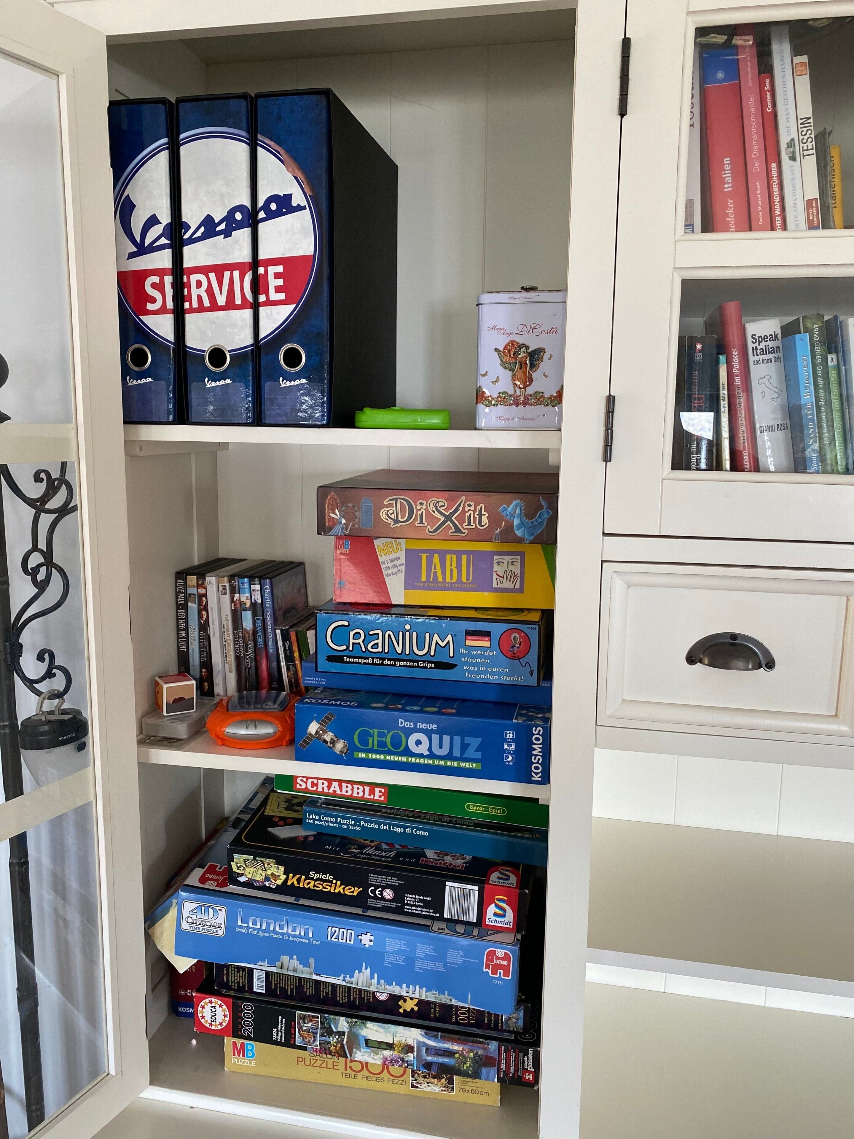 A bookshelf with various board games and puzzles.