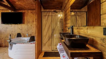 Een houten interieur met een bubbelbad, een grote spiegel en een wastafel.
