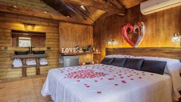 Een houten kamer met een bed, een hartvormige ballon en een ‘LOVE’ bord.