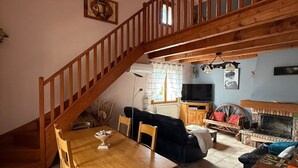 A spacious living area with a wooden staircase, a dining table, and a fireplace. - Chez Polo - House with swimming pool in Vallon-Pont-d'Arc (Vallon-Pont-d'Arc)