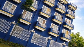 A multi-story building with a sign reading 'ARYAN HOME STAY' and balconies with railings.