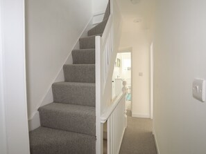 A staircase with carpeted steps and white railings leading to a bathroom. - Bodefi (Pwllheli)