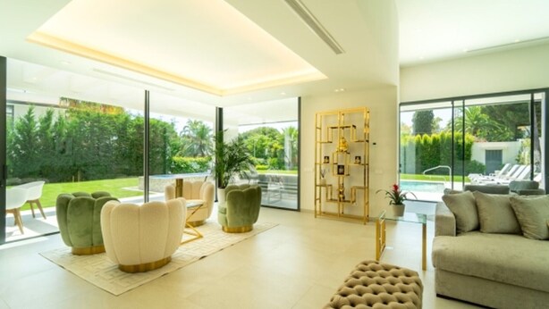 A modern living room with a glass partition, a pool view, and a geometric gold decor piece. - Luxury villa with sea view - 10 guests (Marbella)
