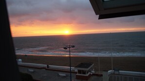 A sunset view from a window overlooking a beach with a bench and a small building. - 3 beautiful sea views (Villers-sur-Mer)