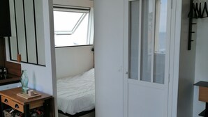 A compact room with a bed, a desk with a chair, a wardrobe, and a window. - 3 beautiful sea views (Villers-sur-Mer)
