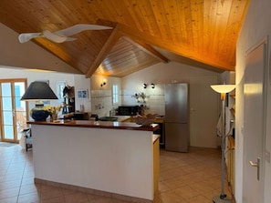 A kitchen with a wooden ceiling, a central island, a refrigerator, and a microwave. - Spacious house near the beach - 10 guests (Noirmoutier-en-l'Île)