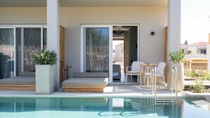 A pool area with a seating area, a table, and chairs. - Seagonia (Aktio-Vonitsa)