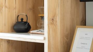 Een houten plank met een waterkoker, een ingelijst document en een glazen pot.