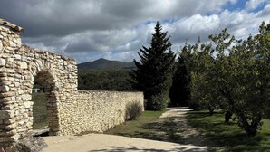 A stone structure with an archway, a paved path, and trees in a natural setting. - Charming house in Drôme provençale - Ventoux view - 10 min from Grignan (Salles-sous-Bois)