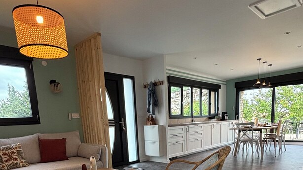 A spacious living area with a large window, a dining table, and a sofa. - Charming house in Drôme provençale - Ventoux view - 10 min from Grignan (Salles-sous-Bois)