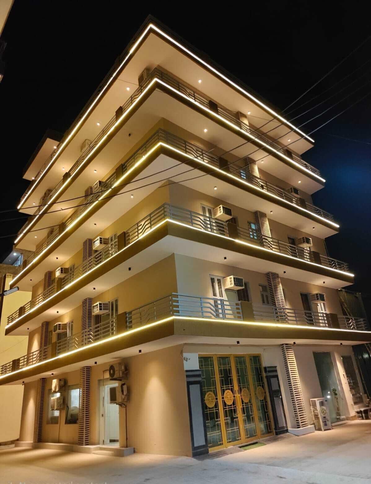 A multi-story hotel with balconies, a glass entrance, and a modern design.