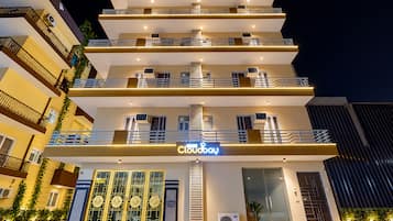Un hotel de varios pisos con un llamativo letrero 'Cloudbay', balcones y un diseño arquitectónico moderno.