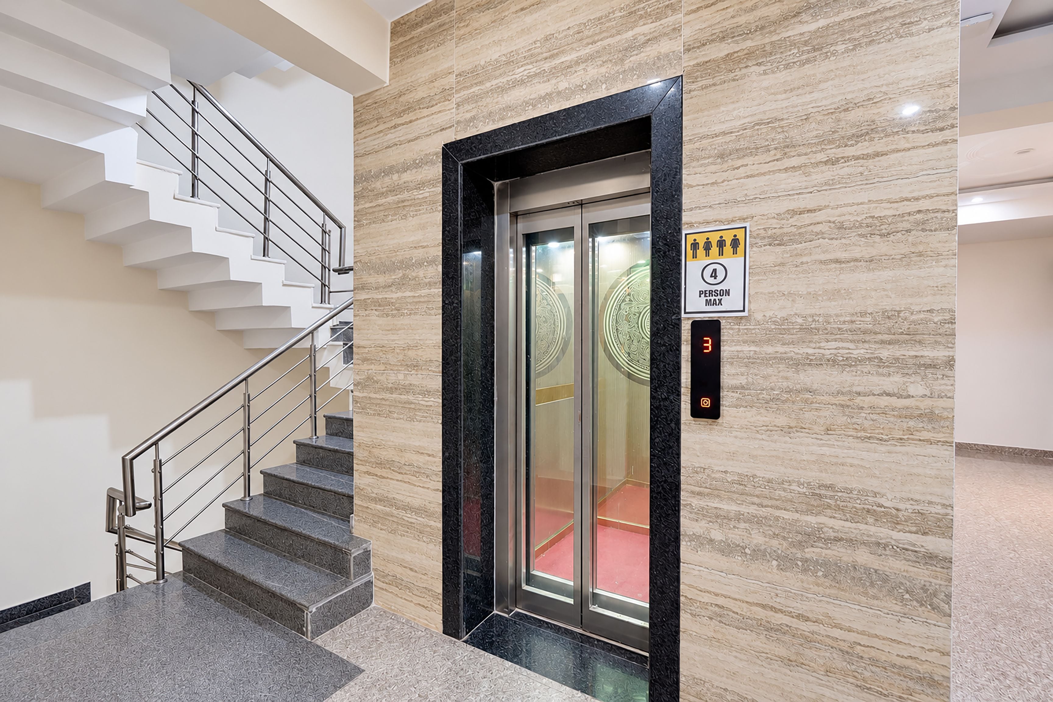 Un ascensor modern amb pantalla digital, icona de persona i indicador de capacitat m àxima.