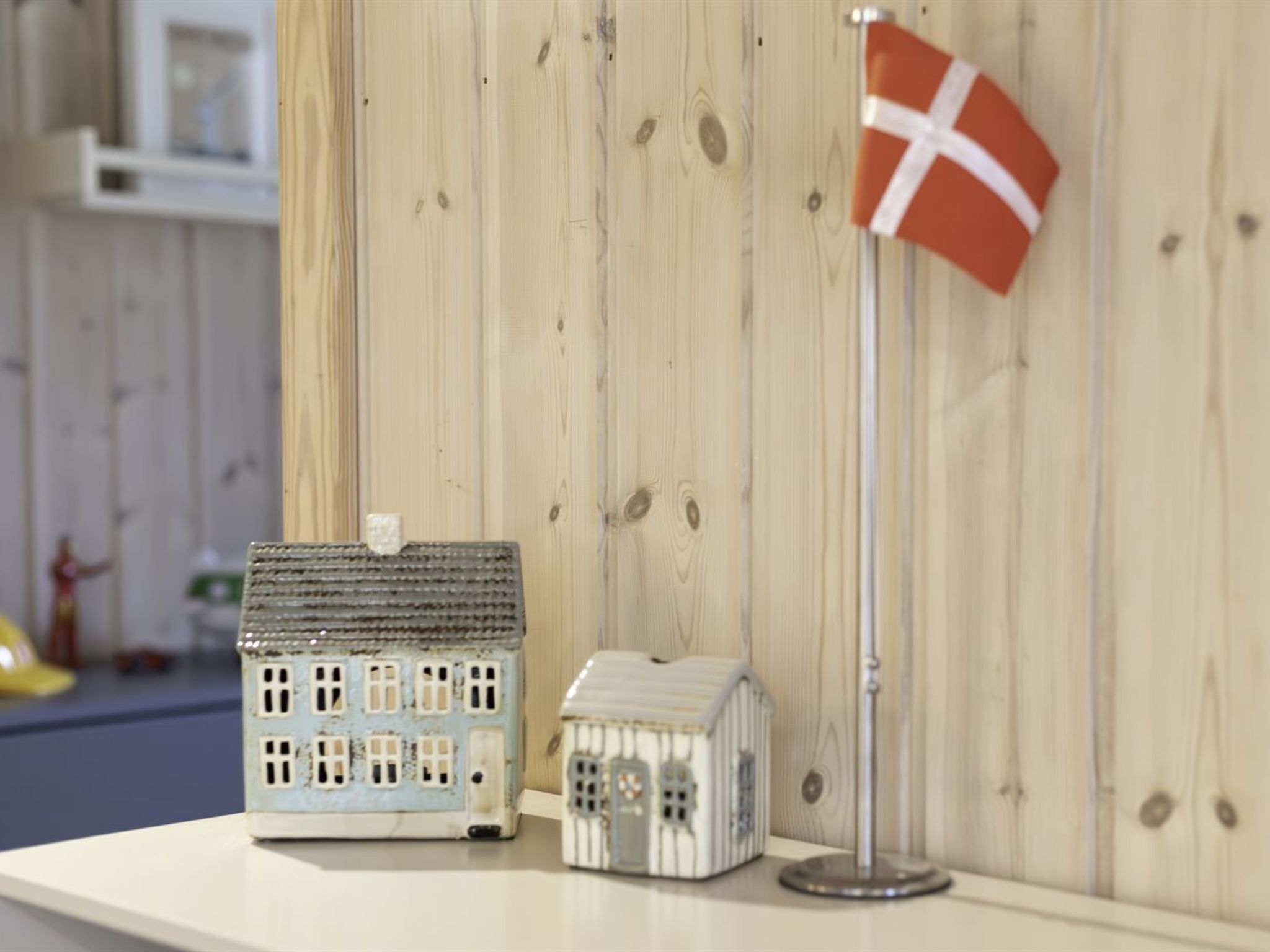 Two model houses on a wooden surface with a flag.
