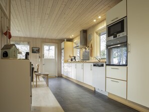 A modern kitchen with white cabinets, a built-in oven, and a window overlooking the outdoors. - "Daya" - 575m from the sea by Interhome (Dannemare)