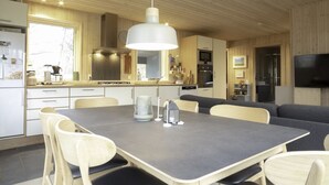 Eine moderne Küche mit Essbereich, Holzboden und integrierten Geräten.