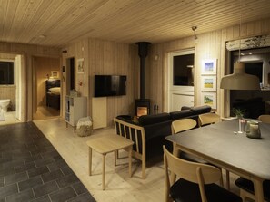 A cozy cabin interior with a dining area, a living room with a sofa, a television, and a fireplace. - "Daya" - 575m from the sea by Interhome (Dannemare)
