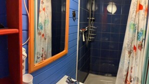 Ein Badezimmer mit Dusche, Spiegel und einem Fenster mit Vorhang.
