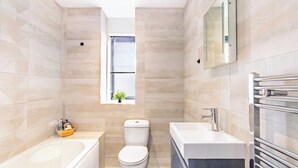 Ein modernes Badezimmer mit Badewanne, Toilette und Waschtisch.