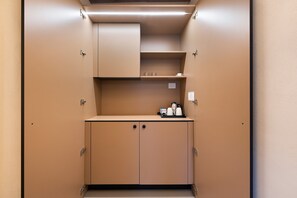 A kitchenette with cabinets, a countertop, and a coffee maker.