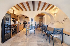 An interior with a dining area, kitchen, and wine storage.