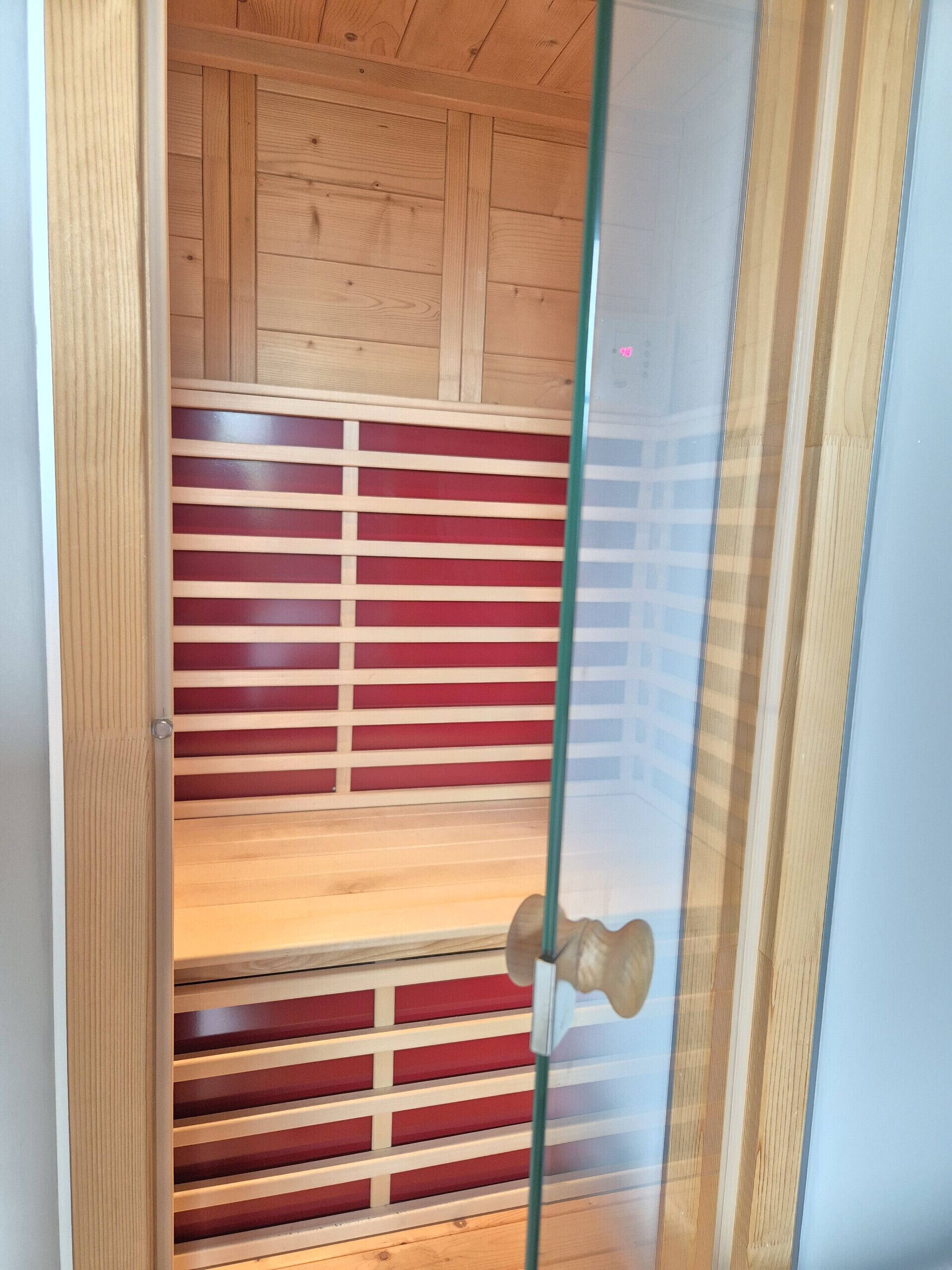 A room with wooden paneling, a glass door, and a red and white striped partition.