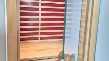 A room with wooden paneling, a glass door, and a red and white striped partition.