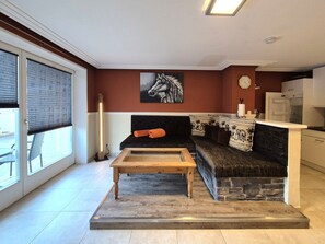 Una sala de estar con sofá, mesa de centro, chimenea y espacio para la cocina.