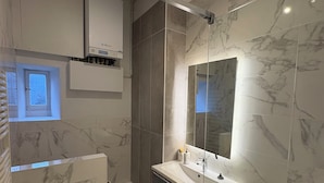A modern bathroom with a marble floor, a glass shower enclosure, a white sink, and a large mirror. - T3 hyper center near train station (Bourgoin-Jallieu)