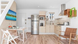 A modern kitchen with a stainless steel refrigerator, wooden cabinets, a microwave, and a sink. - Charming 1BR in Pueblo Mijitas with Terrace by Mijas Golf (Mijas)