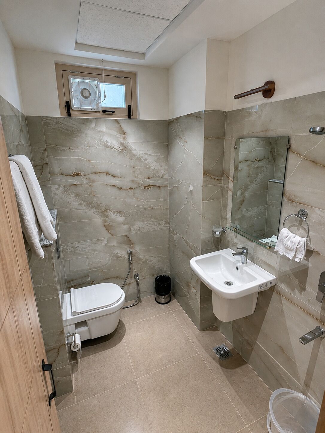 Ein Badezimmer mit Toilette, Bidet, Waschbecken, Spiegel und Handtuchhalter.