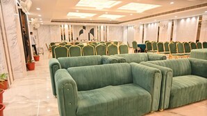 A conference room with green upholstered chairs, marble flooring, and a ceiling with recessed lighting. - Hotel Velvet The Ultimate (Prayagraj)