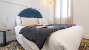 A neatly made bed with a blue headboard, white bedding, and a patterned rug. - Bright Apartment in Granada Center San Anton 301 (Granada)