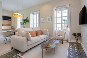 A modern living room with a sofa, coffee table, and chairs, a dining area with a table and chairs, and a large window with curtains. - Bright Apartment in Granada Center San Anton 301 (Granada)