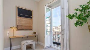 A room with a desk, a bench, a plant, and a door leading to a balcony. - Bright Apartment in Granada Center San Anton 301 (Granada)