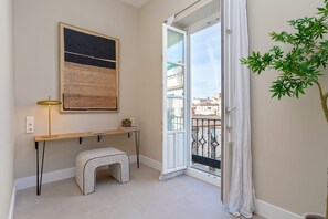 A room with a desk, a bench, a plant, and a door leading to a balcony. - Bright Apartment in Granada Center San Anton 301 (Granada)