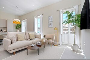 A modern living room with a sofa, coffee table, armchair, and a potted plant. - Bright Apt in the Heart of Granada San Anton 304 (Granada)
