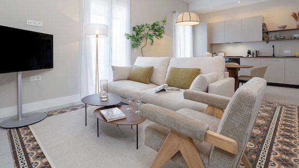 A modern living room with a sofa, armchair, coffee table, and a flat-screen TV. - Luxurious 3 bd Apartment in Granada San Anton 302 (Granada)