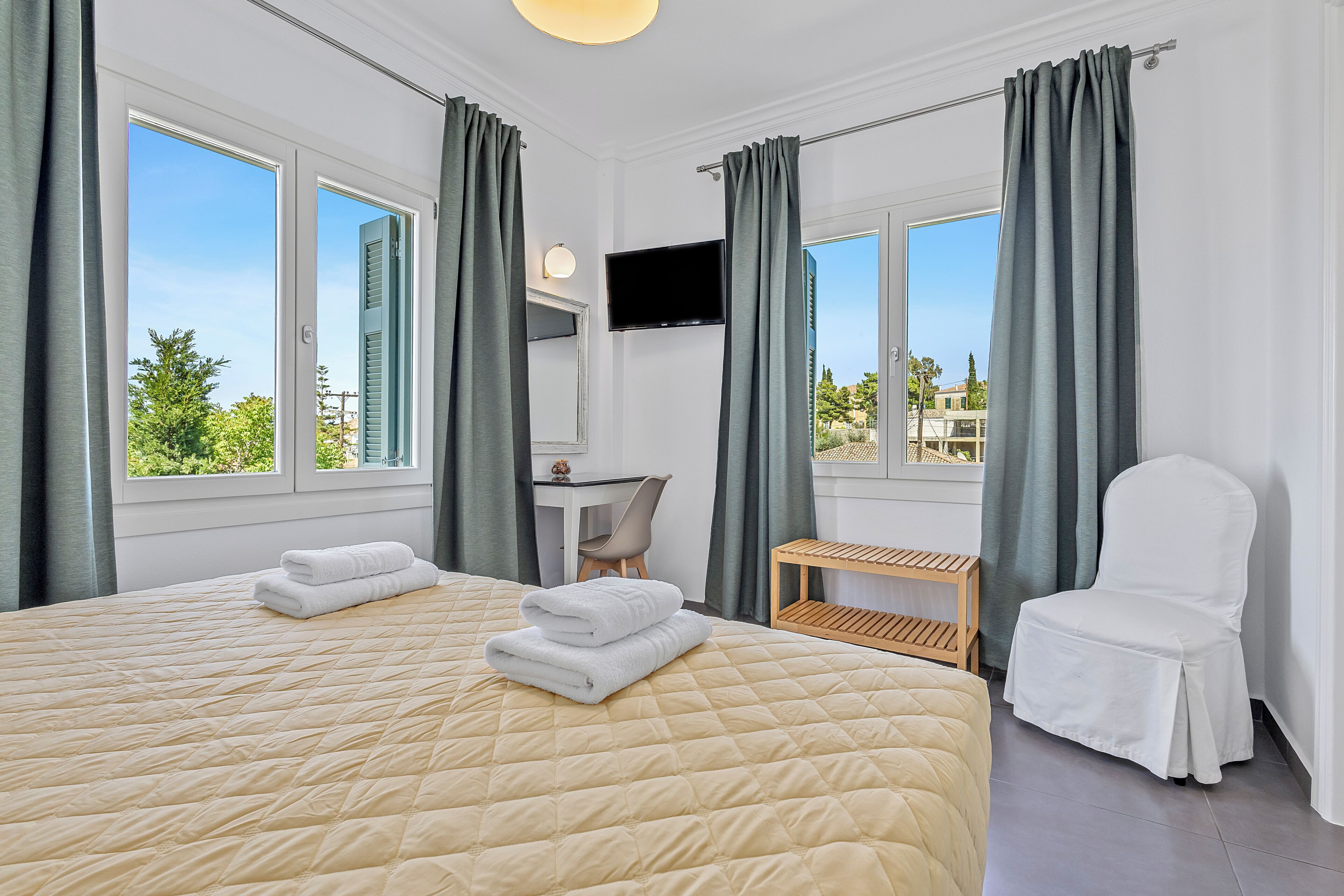 Una habitación de hotel con una cama grande, un escritorio, una silla y un televisor.