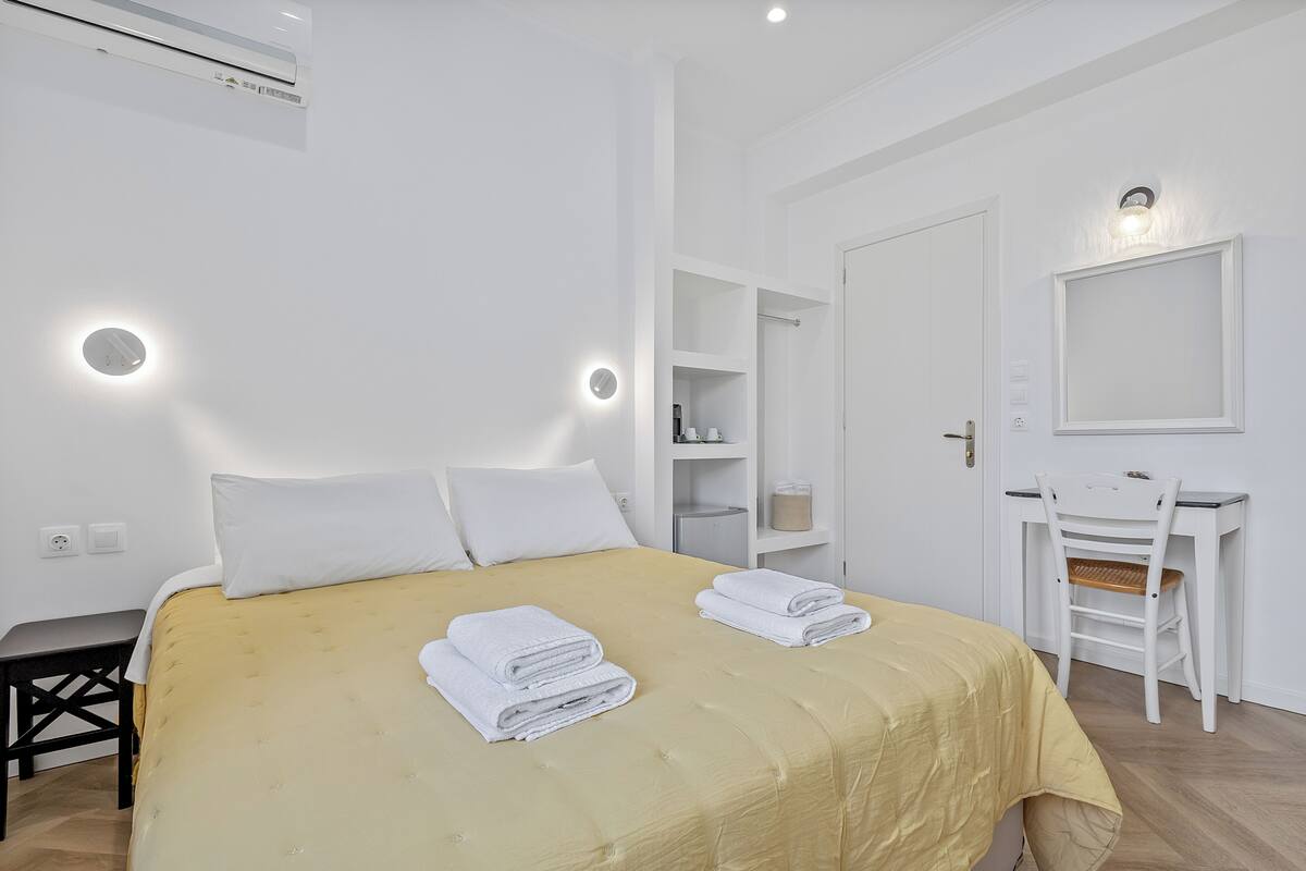 Una habitación de hotel con cama, escritorio, silla y armario.