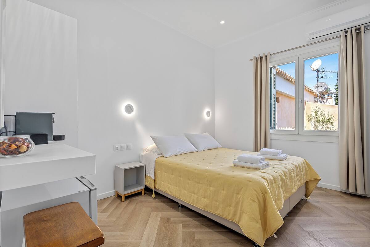 Un dormitorio moderno con una cama, una mesita de noche y un escritorio con un frutero.
