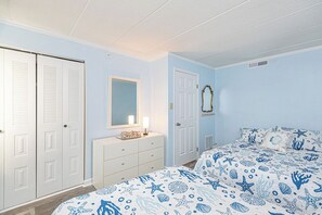 Ein Schlafzimmer mit Bett, Schminktisch, Spiegel und Kleiderschrank.