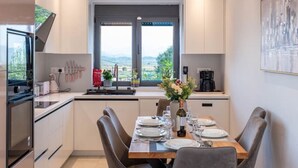 Une cuisine moderne avec un coin repas, équipée d’une cuisinière, d’un four et d’un évier.