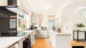 A modern kitchen with a central island, built-in appliances, and a view to the outside.