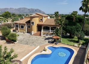 A residential property with a swimming pool, a patio area, and a view of distant mountains. - Villa 'Emilio' with Sea View, Private Pool and Wi-Fi (Alicante)