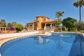 A large house with a swimming pool, surrounded by palm trees and other greenery. - Villa 'Emilio' with Sea View, Private Pool and Wi-Fi (Alicante)