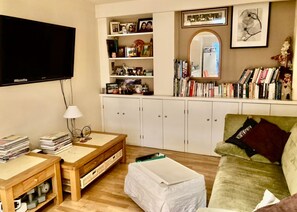 A living room with a television, a bookshelf, a mirror, and a green couch. - Pay30nghts get up tp Extra 59 Free (London)