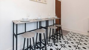 A bar area with stools, a long table, and a patterned floor. - Free Parking Sleeps 2 Central Location (Reading)