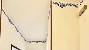 Un pasillo con baldosas decorativas en el techo, un banco y un adorno en la pared.